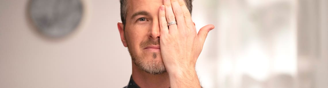 Someone holding their hand over their eye during a vision exam.