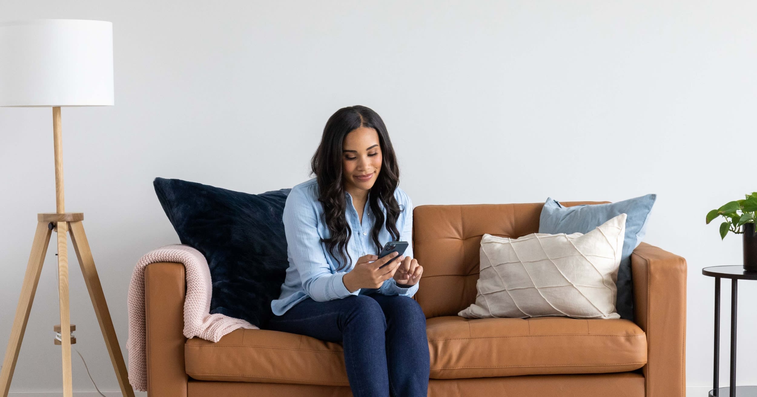 Someone sitting on a couch taking an online vision exam on their phone.